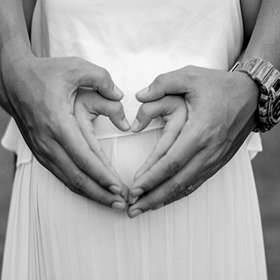 preconception-planning couple hopeful for pregnancy hands on belly